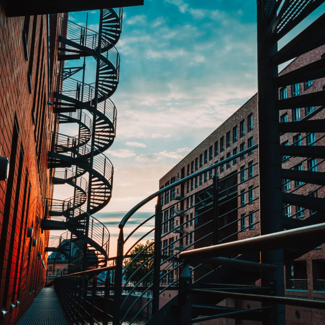 Spiral staircases in the old Warehouse District. Narrow canal and red brick buildings of Speicherstadt in Hamburg. After sunset