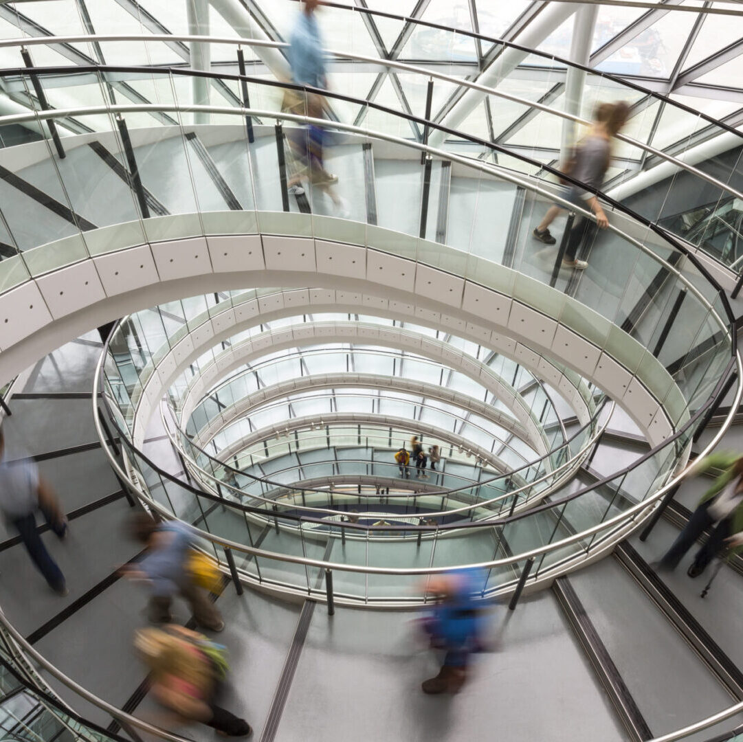 London,England,Interior view of building with people walking along glass and metal spiral staircase.